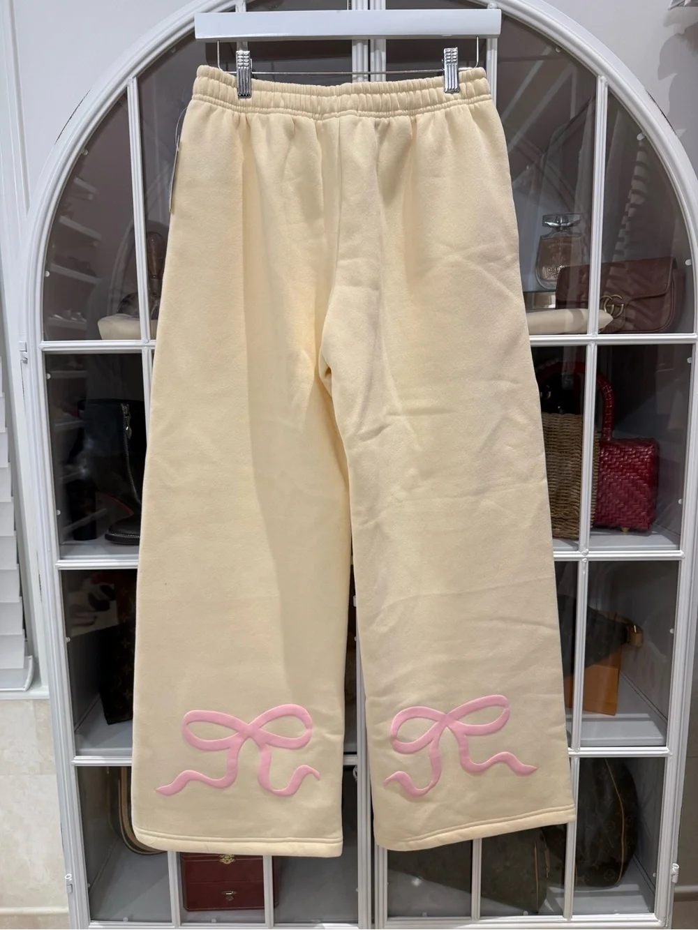 Edikted Cream/Light YellowTrack Pants with Pink Bow Detail on back of pants.